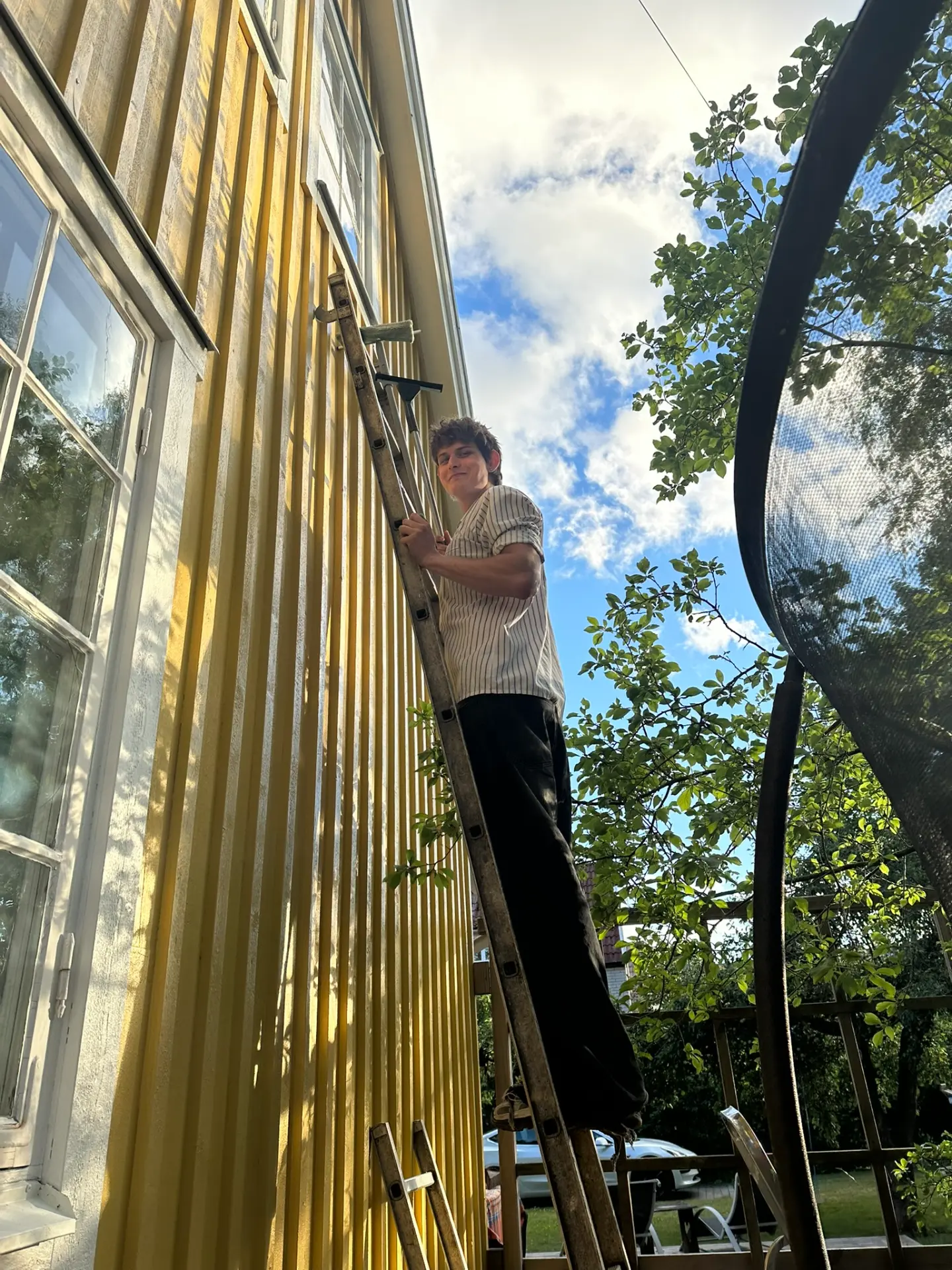 Fönsterputsare från Putskompaniet Roman på stege vid ett villafönster i Stockholm